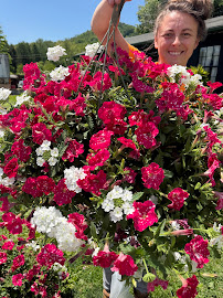 A huge hanging basket overflowing with pink and white blooms, held up proudly