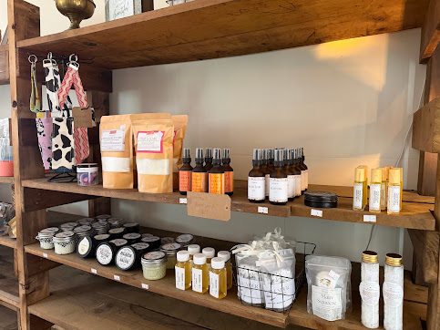 Wooden market shelves stocked with non-toxic body products, jars, sprays, and refillery goods